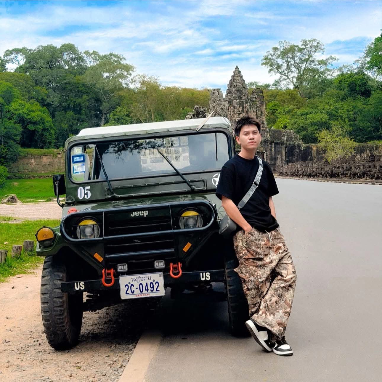 Driver leaning on vintage military Jeep at Angkor Thom south gate